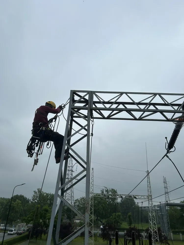 Zdjęcie przedstawia alpinistę przemysłowego podczas pracy na wysokości.