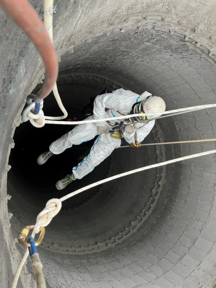 Zdjęcie przedstawia alpinistę przemysłowego podczas pracy na wysokości.